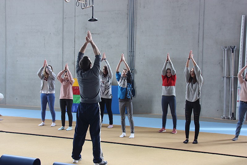 Ein Lehrer Macht Qi Gong, Schülerinnen machen die Pose nach.